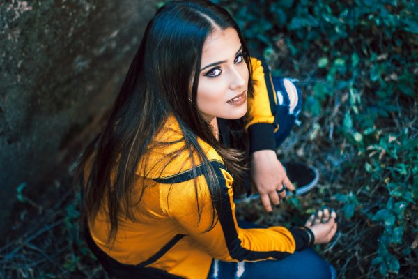 Sitting-girl-charming-brunette-yellow-jacket-brown-eyes-gaze