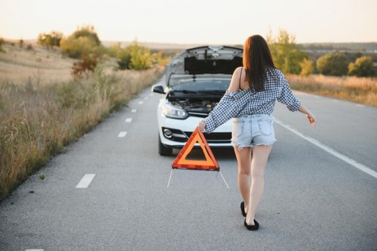 Beautiful-sexy-woman-holding-emergency-stop-sign-near-broken